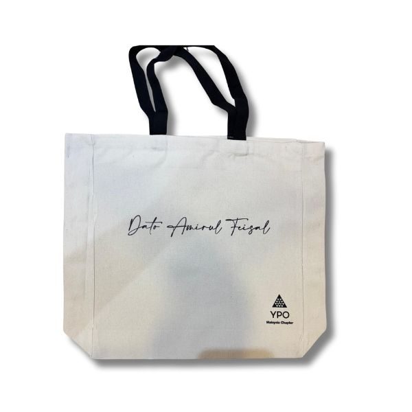 White canvas tote bag with black handles, featuring the name 'Dato Amiral Feisal' in cursive script and the YPO Malaysia Chapter logo on the bottom right.