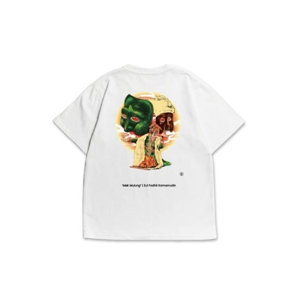 White t-shirt featuring a colorful illustration on the back, showcasing two traditional masks and a figure in cultural attire, with the text 'Met Mukung' and 'Tajul Fadhli Kamarudin' at the bottom.