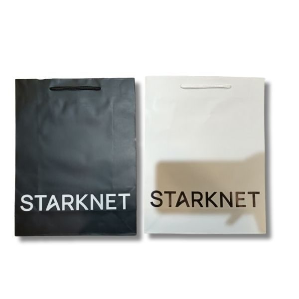 Two branded Starknet paper bags, one black with white lettering and the other white with black lettering, featuring the Starknet logo.
